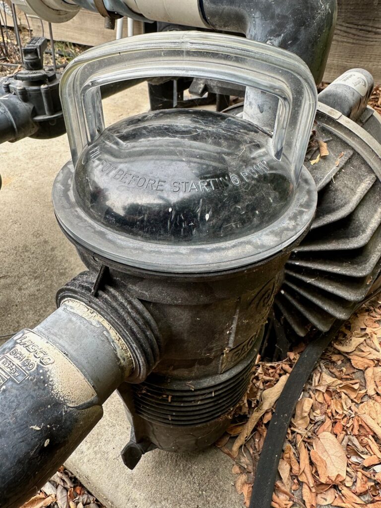 Pool pump lid and strainer housing inspected for a swimming pool leak